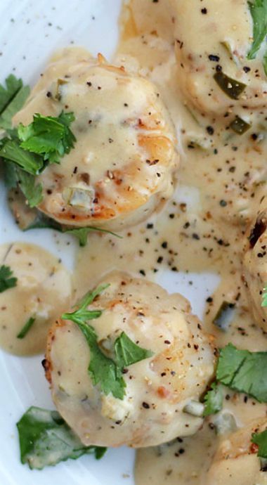 a white plate topped with meat covered in gravy and garnished with parsley