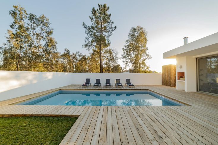 a wooden deck next to a swimming pool