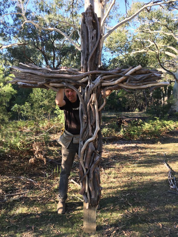 a man climbing up the side of a wooden cross