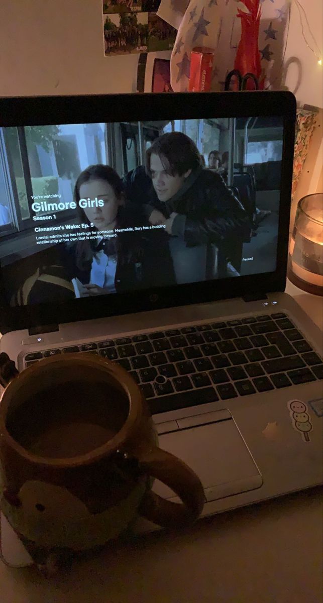 an open laptop computer sitting on top of a wooden table next to a coffee mug