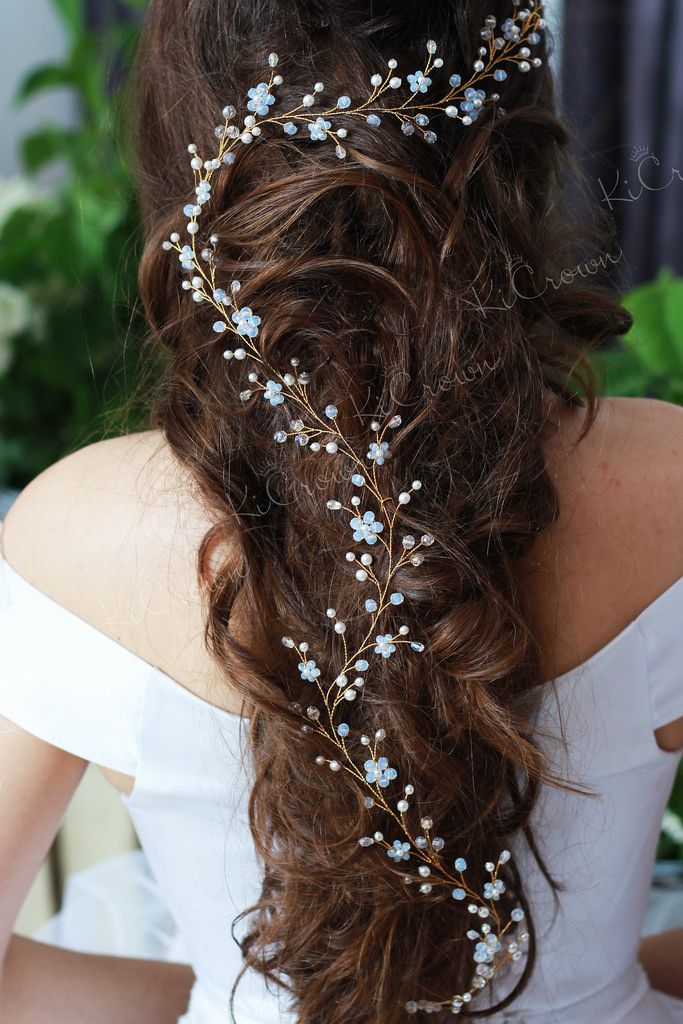 a woman with long hair wearing a white dress and a flower headpiece in her hair