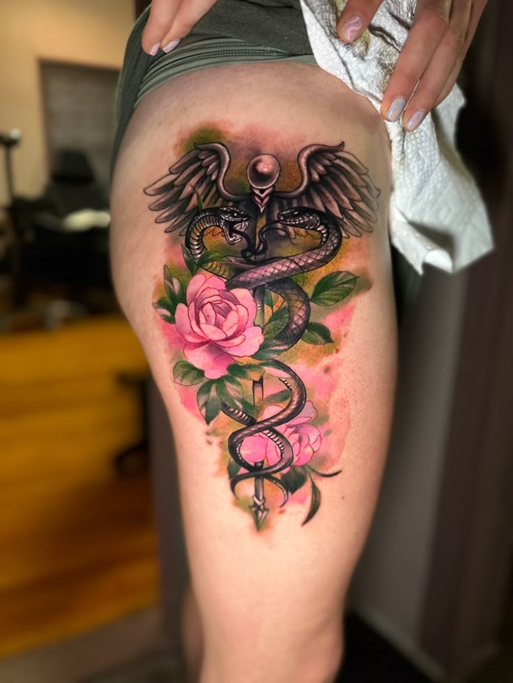 a woman's thigh with tattoos and roses on the side, in front of her