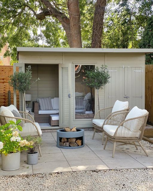 an outdoor living area with chairs and a fire pit