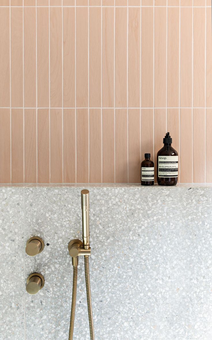 a bathtub with gold faucet and soap dispenser