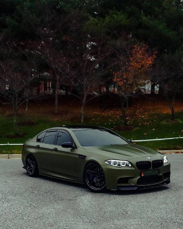 a green car is parked in the parking lot