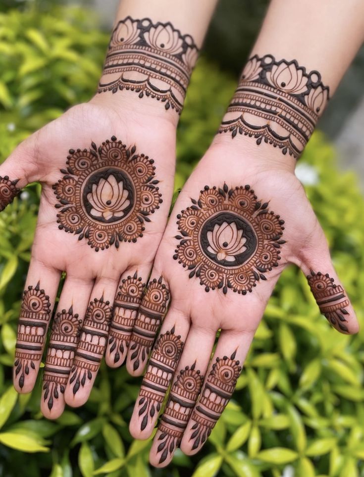 two hands with henna tattoos on them