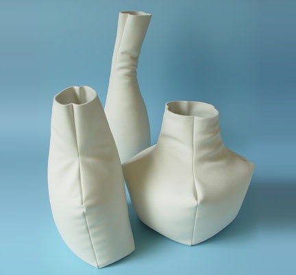 three white vases sitting next to each other on a blue background