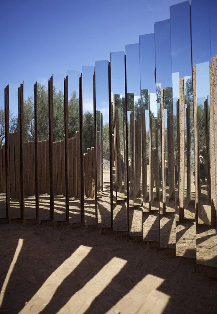 several mirrors are arranged in the shape of poles and logs, with shadows cast on them