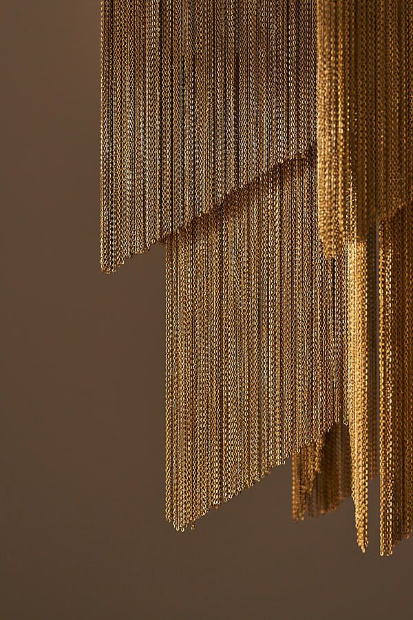 a close up view of some gold chains hanging from a ceiling fixture in a room