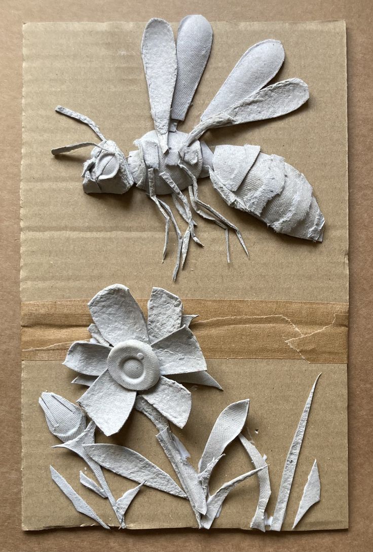 paper mache flowers and bugs on cardboard