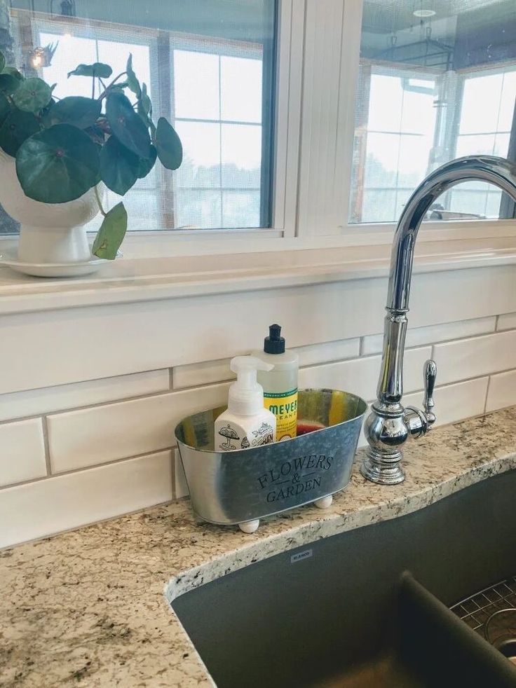 a kitchen sink under a window next to a counter