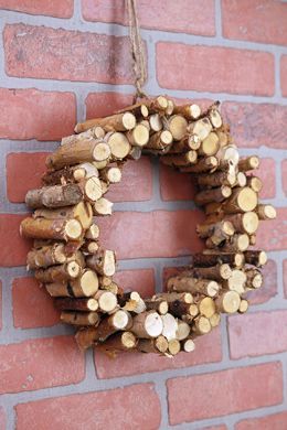 a wreath made out of logs on a brick wall