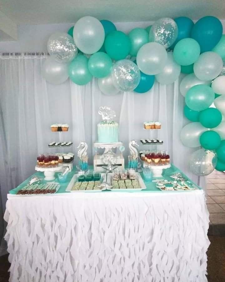 a table topped with lots of desserts and balloons