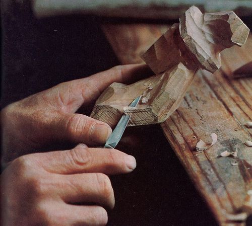 a person is working on some wood with a small plane in their hand and another piece of wood next to them