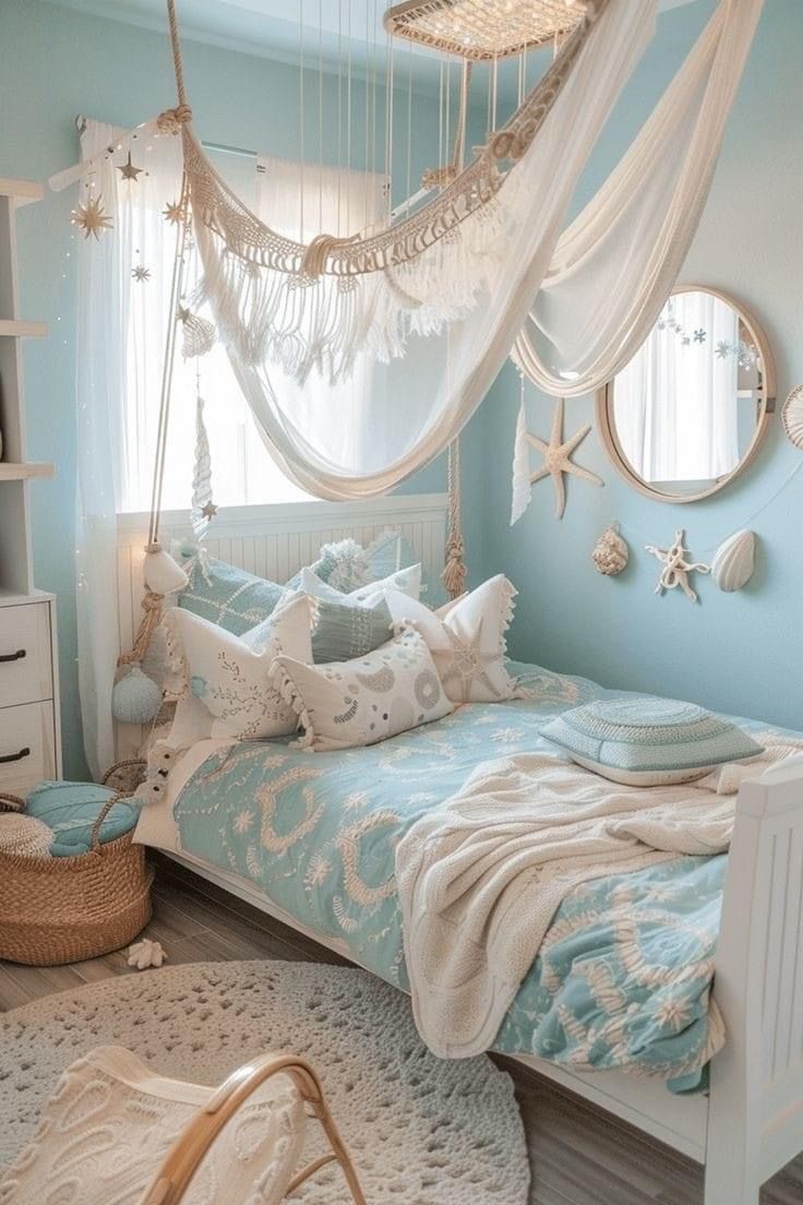 a bedroom with blue walls, white bedding and a hammock hanging from the ceiling