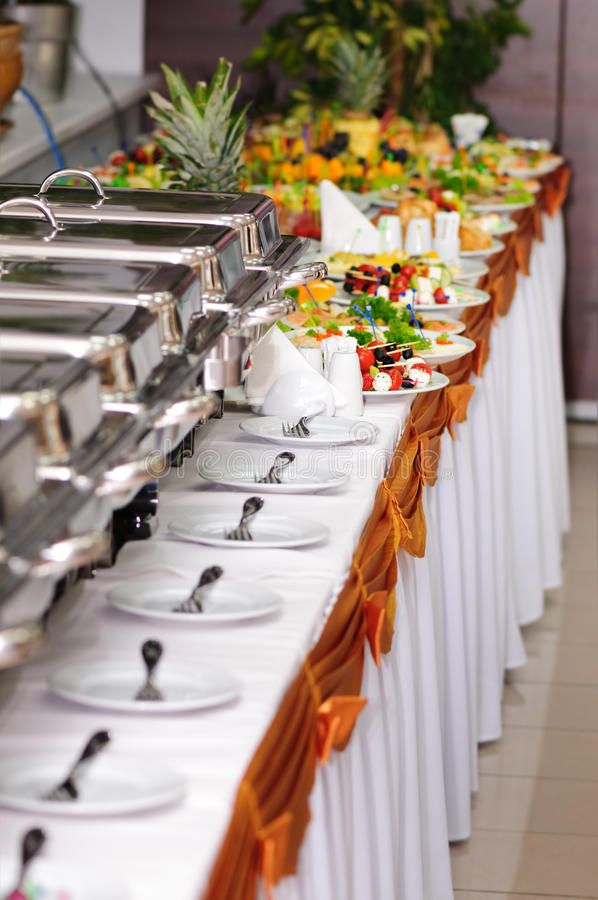 a buffet table filled with lots of different types of food on plates and serving utensils