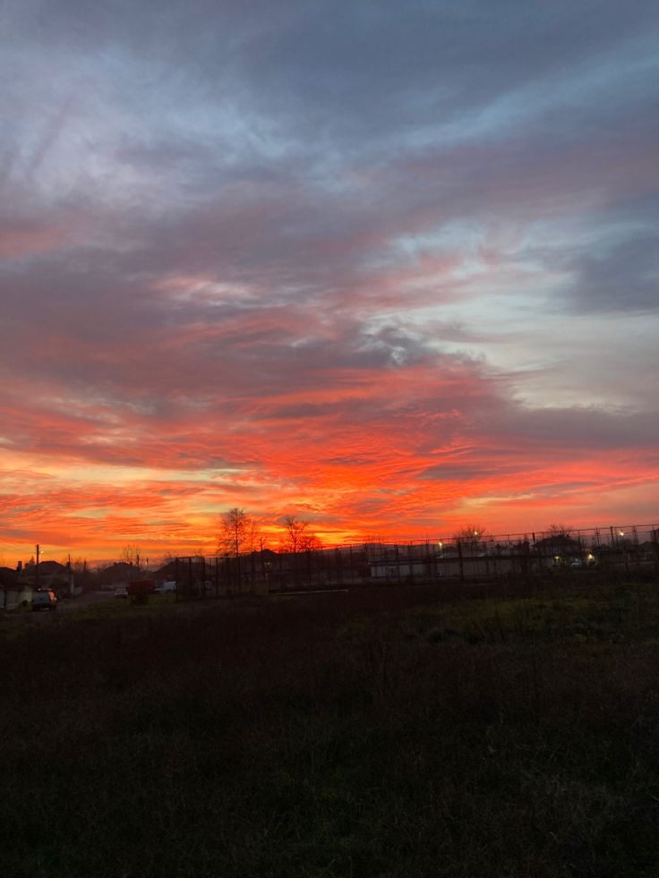 the sun is setting over an empty field