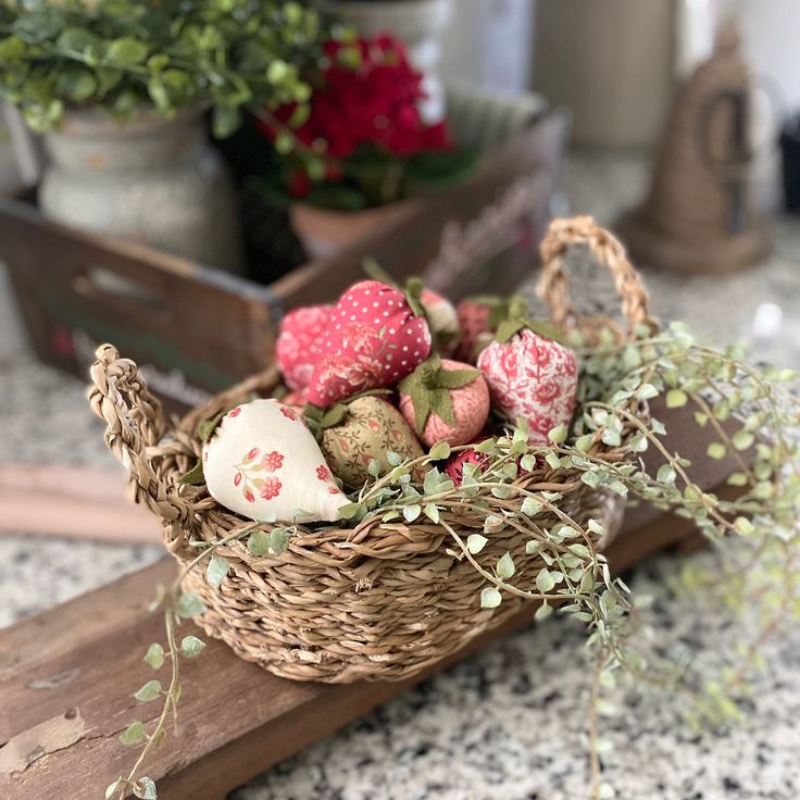 a basket filled with strawberries sitting on top of a counter next to potted plants