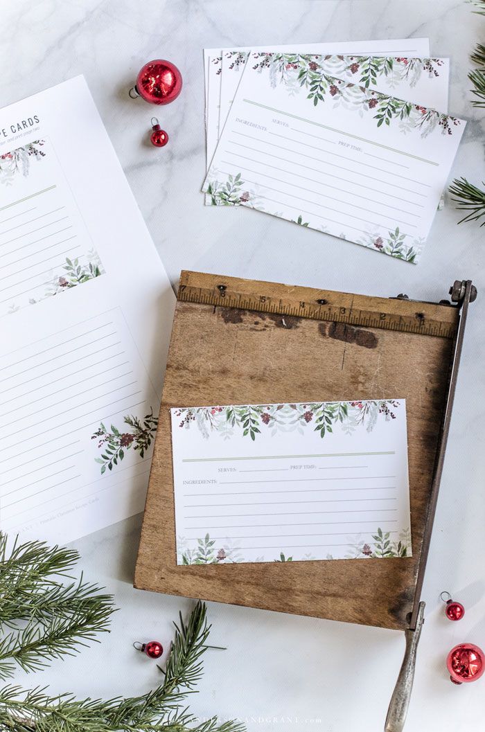 three christmas notepads sitting on top of a wooden box next to evergreen branches