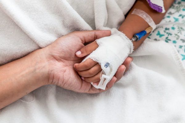 a person holding an infant wrapped in bandages