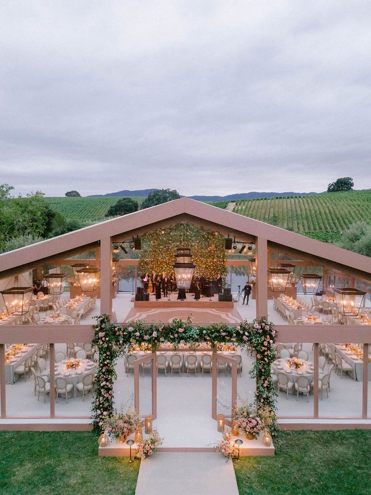 an aerial view of a wedding venue with tables and chairs set up in the grass