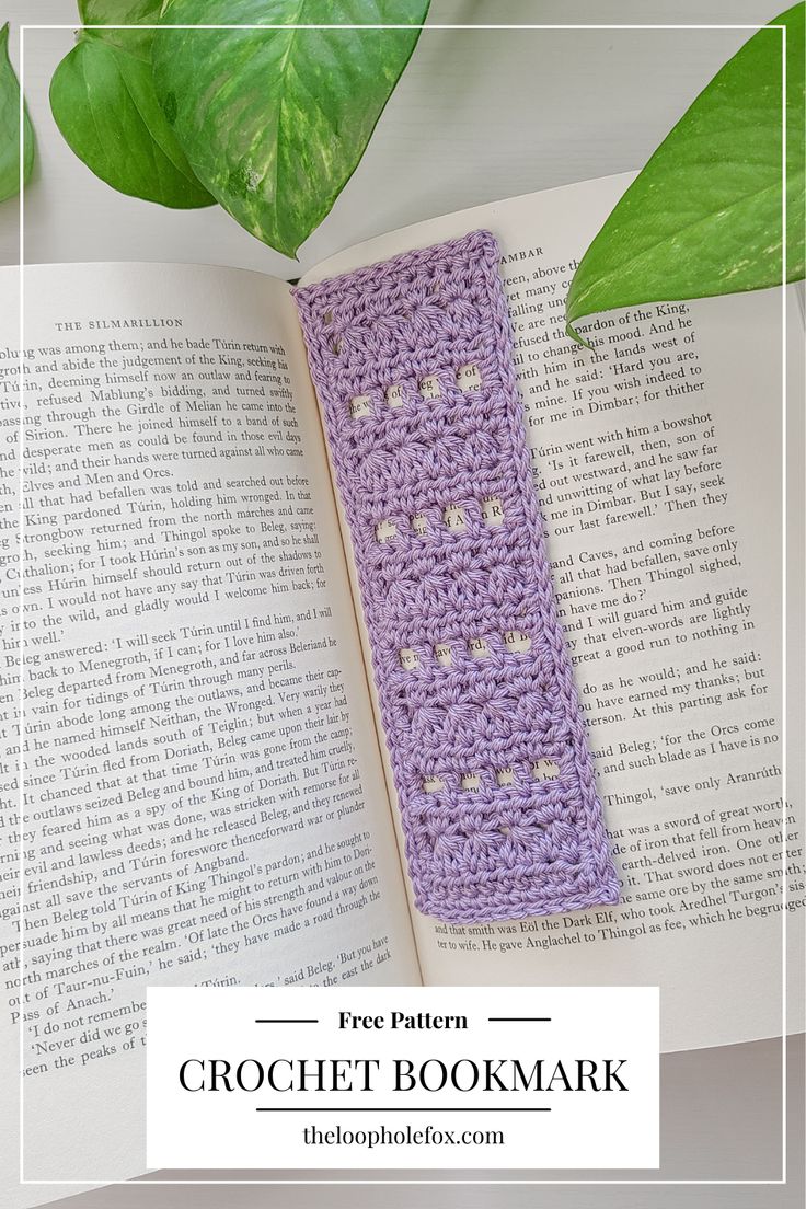 a crochet bookmark sitting on top of an open book next to a plant