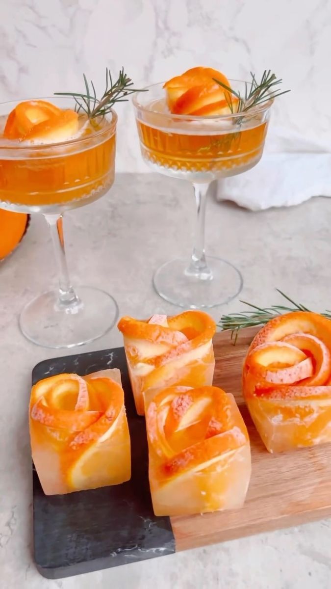 three glasses filled with drinks and sliced oranges