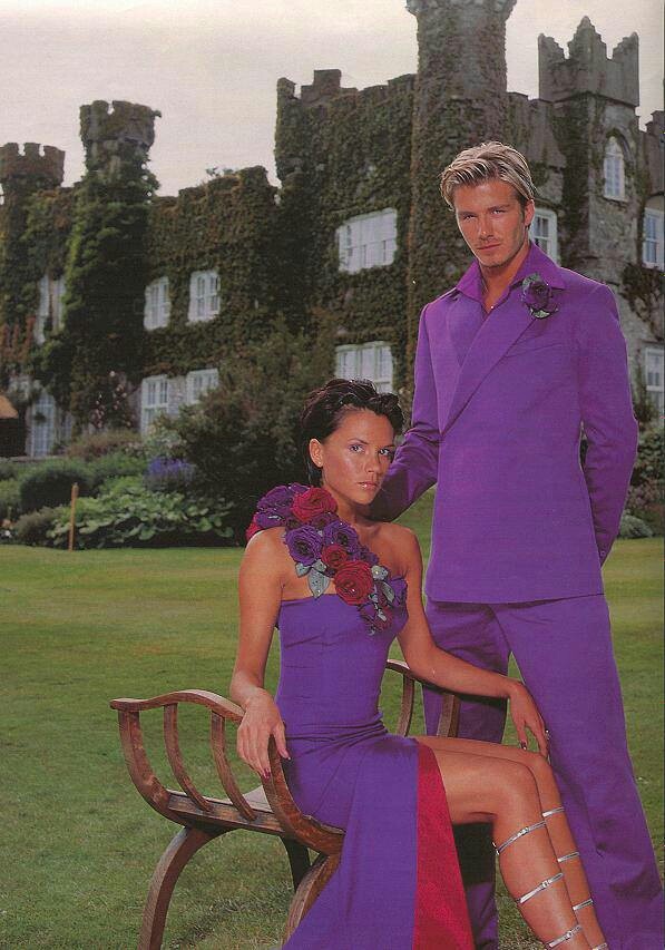 the man and woman are sitting on a bench in front of an old castle building