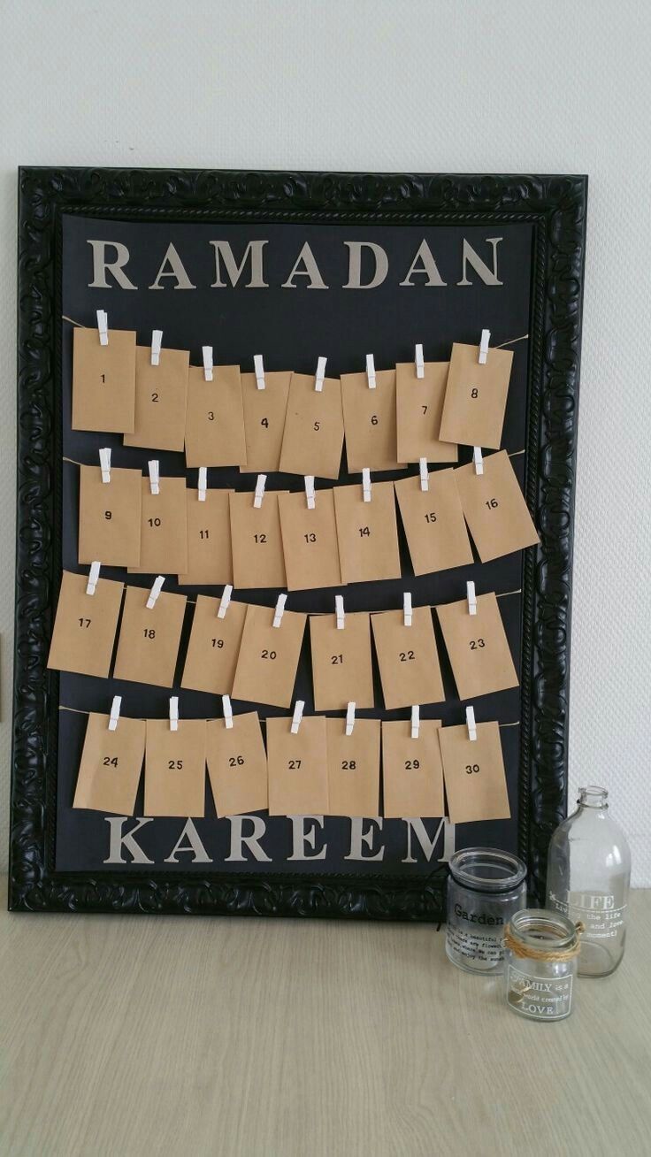 a wooden board with clothes pins attached to it and some glasses on the table next to it