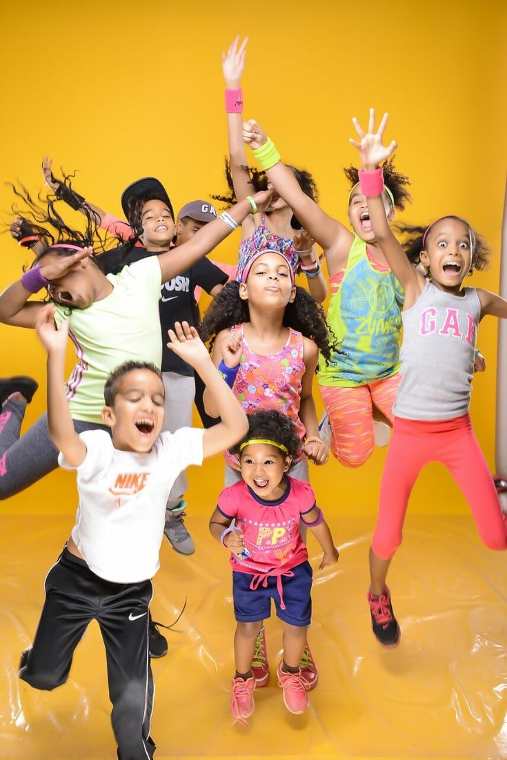 a group of children jumping in the air with their arms up and legs spread out