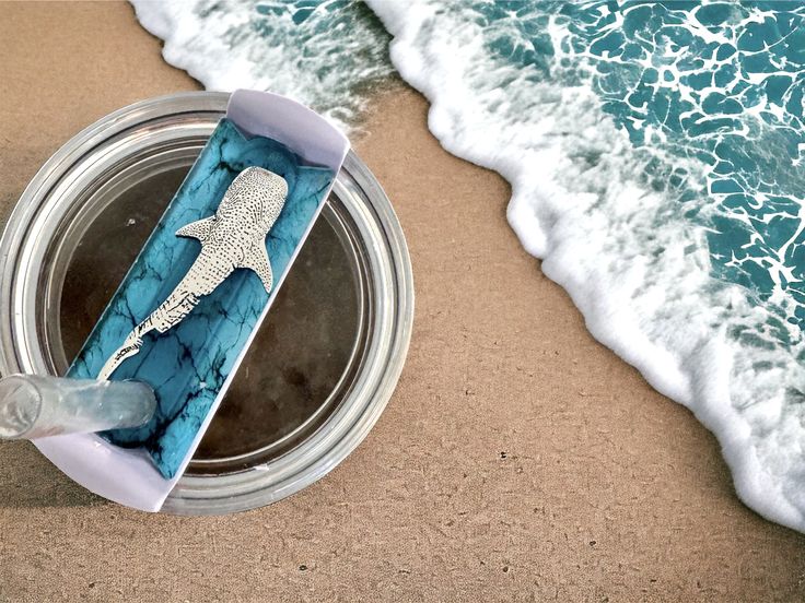 a blue and white box sitting on top of a beach next to the ocean