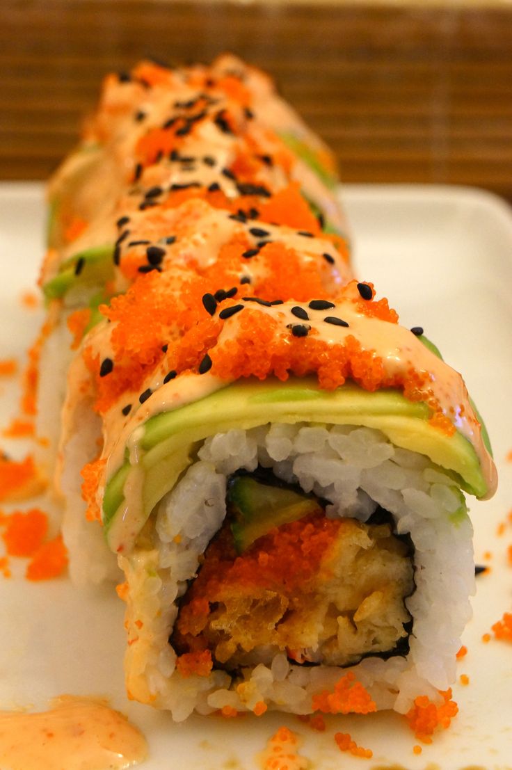 a white plate topped with sushi covered in sauce