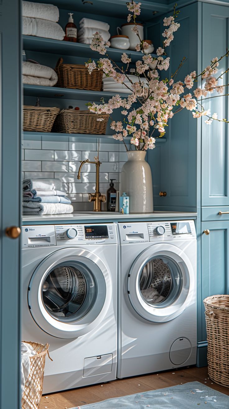 a washer and dryer in a room with blue walls, white tile flooring and open shelving