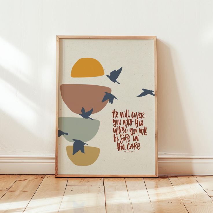 a framed poster with birds flying around it on the floor in front of a white wall