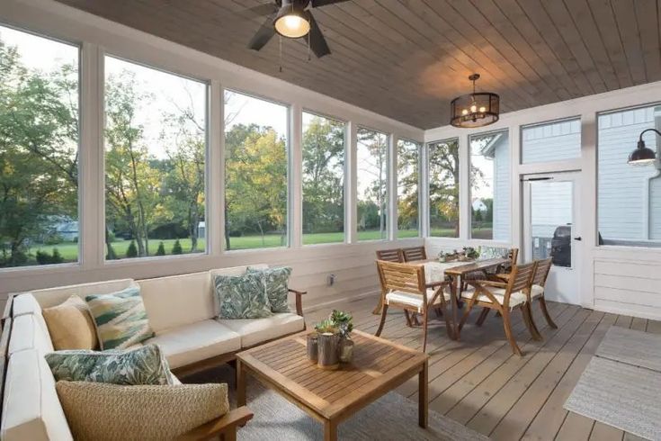 a screened porch with furniture and large windows