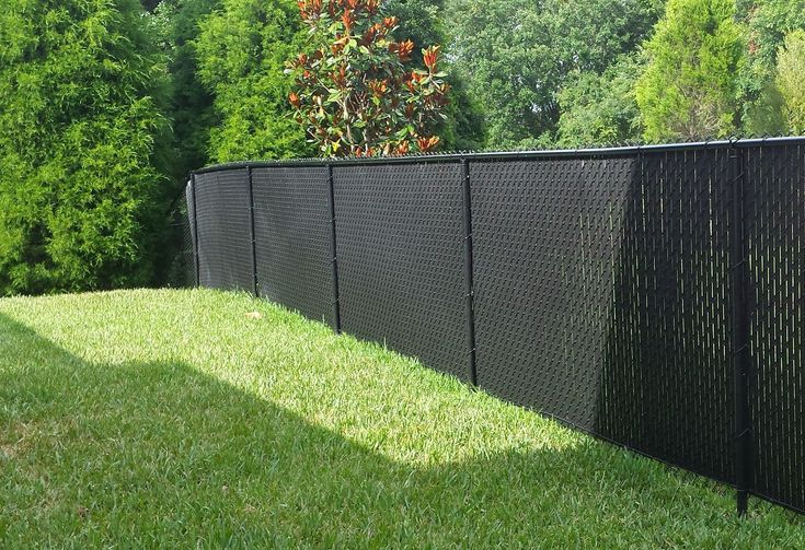 a black fence is in the middle of some grass