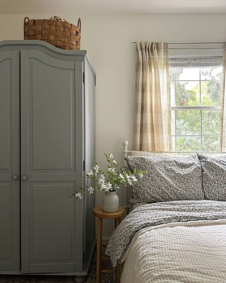 a bedroom with a bed and a gray armoire