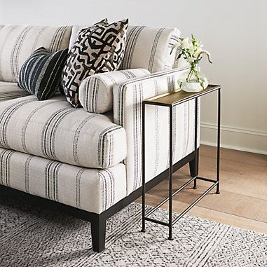 a living room with a striped couch and side table