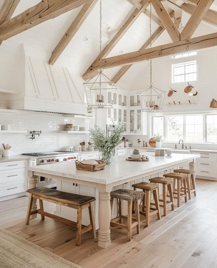 a large kitchen with white cabinets and wooden beams on the ceiling, along with stools