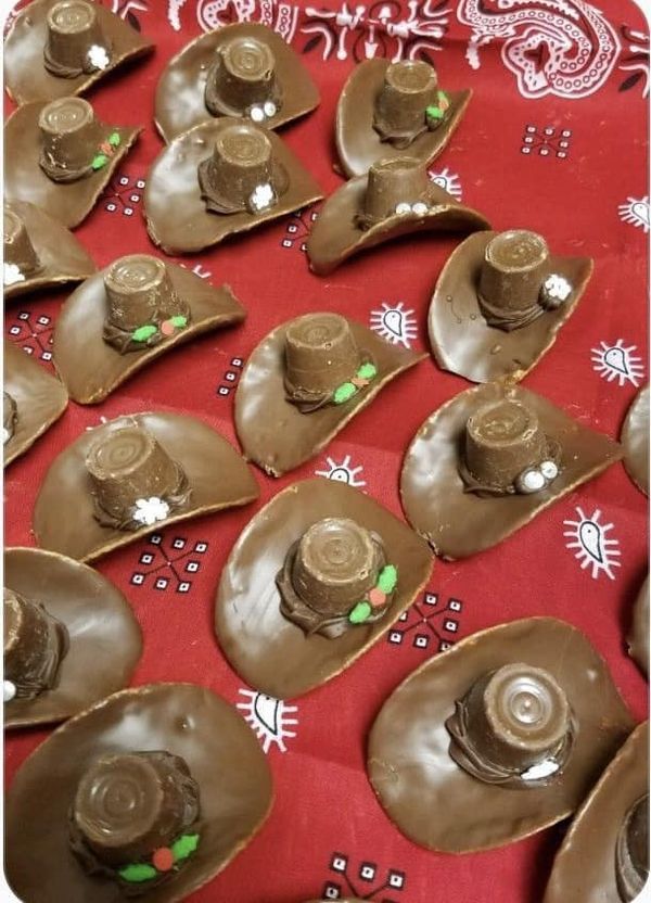 some chocolate hats are sitting on top of each other in the middle of a red table cloth