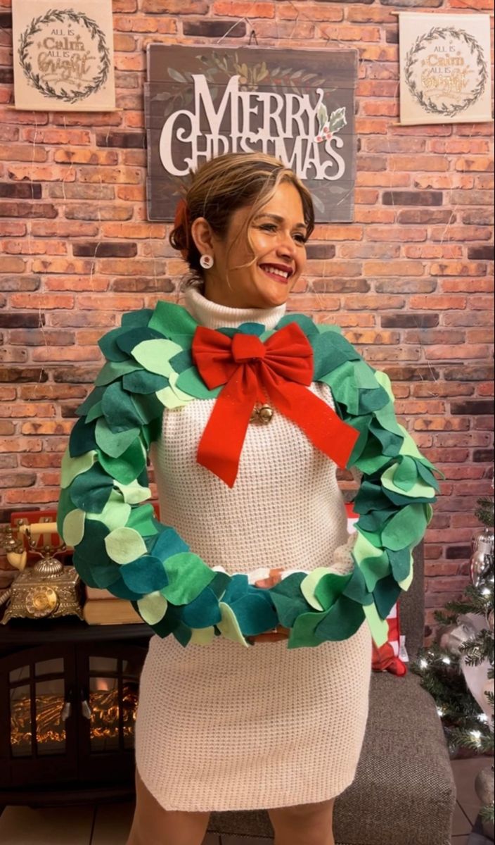 a woman in a christmas sweater with a wreath around her neck and red bow tie