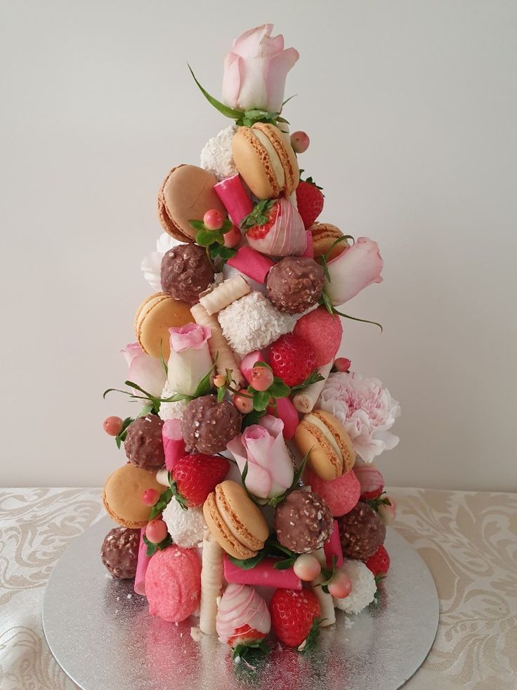 a cake made to look like a tree with macaroons and strawberries on it