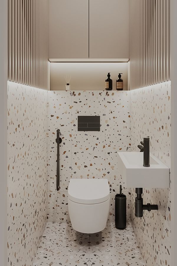 a white toilet sitting in a bathroom next to a sink under a mirror and faucet