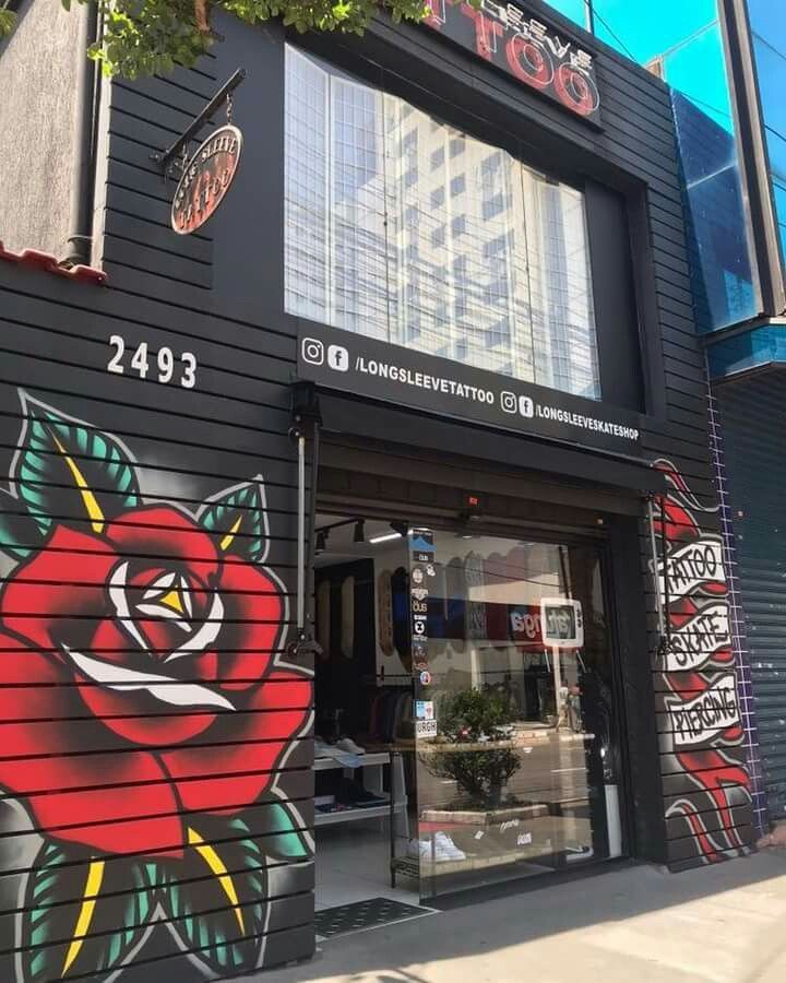 the front of a tattoo shop with graffiti on it's walls and windows,