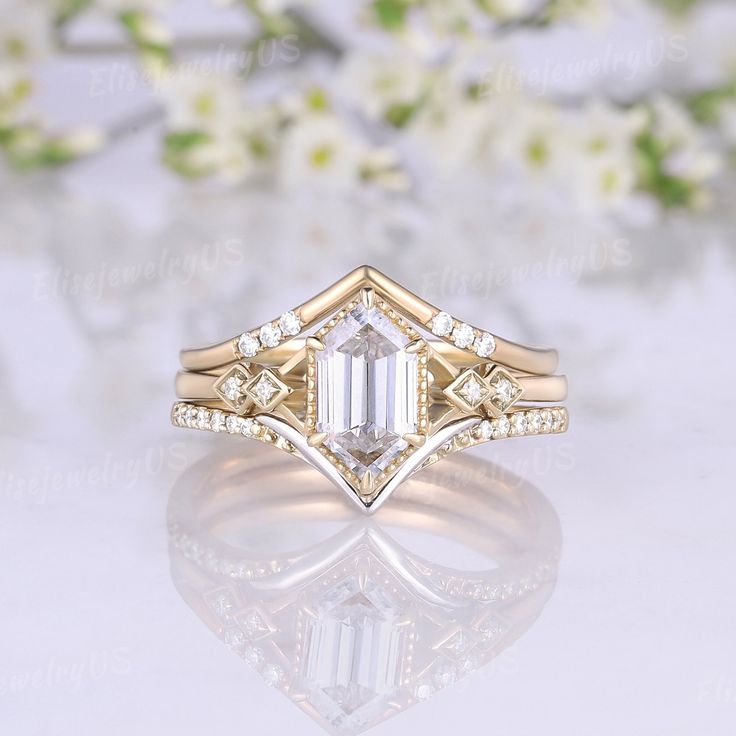 an engagement ring with a large emerald cut diamond in the center, surrounded by small white flowers