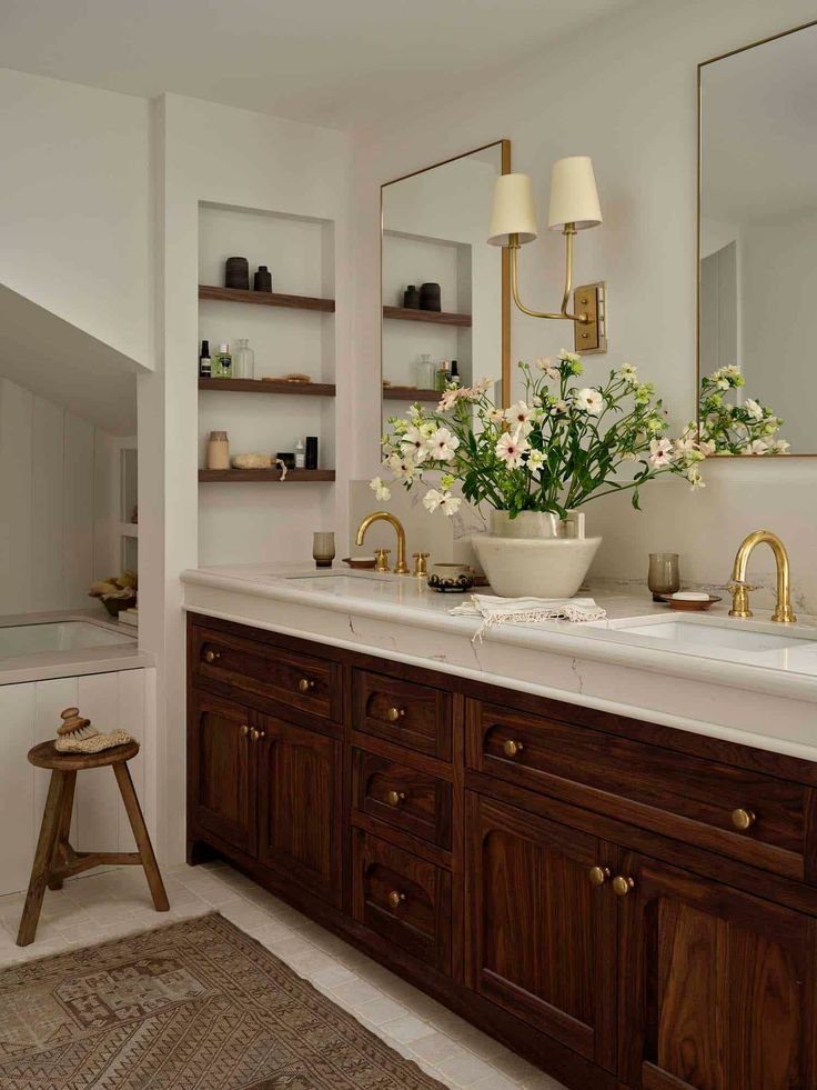 a bathroom with two sinks and wooden cabinets