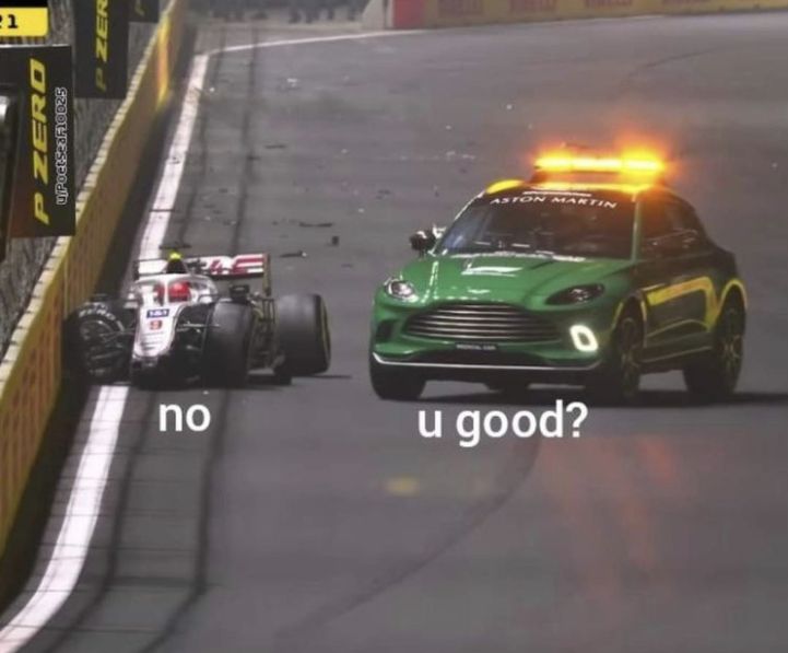 a green race car driving down a track next to a red and yellow racing car