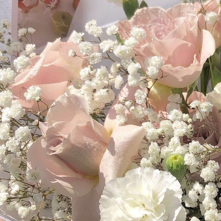 a bouquet of pink and white flowers sitting on top of a table