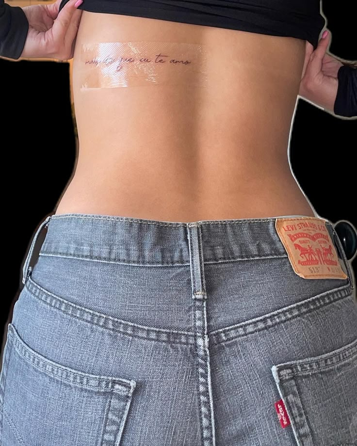 the back of a woman's stomach with tattoos on her lower body and side