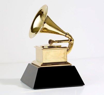 an old fashioned golden record player sitting on top of a black and gold pedestal with a white background